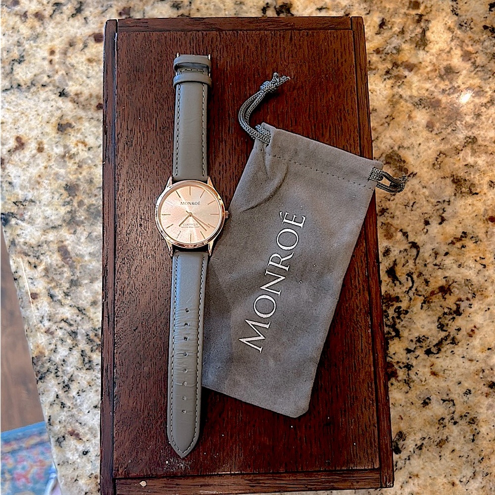 Monroe watch with rose gold face and gray leather band.